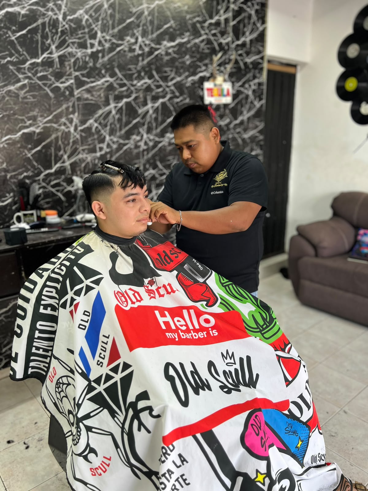 Barbero de Bhalu BarberShop detallando un corte