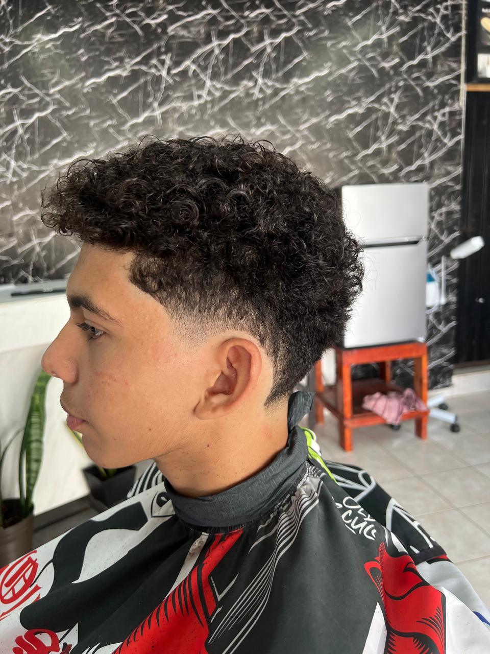 Corte con cabello rizado y desvanecido